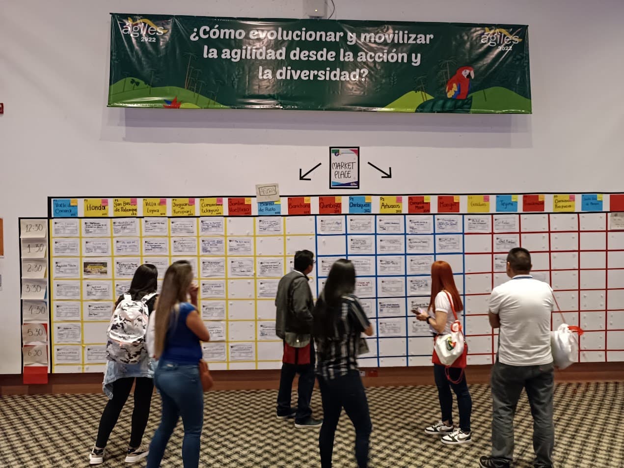 Asistentes revisando el tablero de sesiones del open space